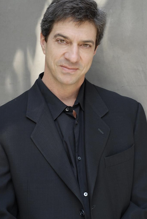 Photo of Author Sam Glaser in a black suit
